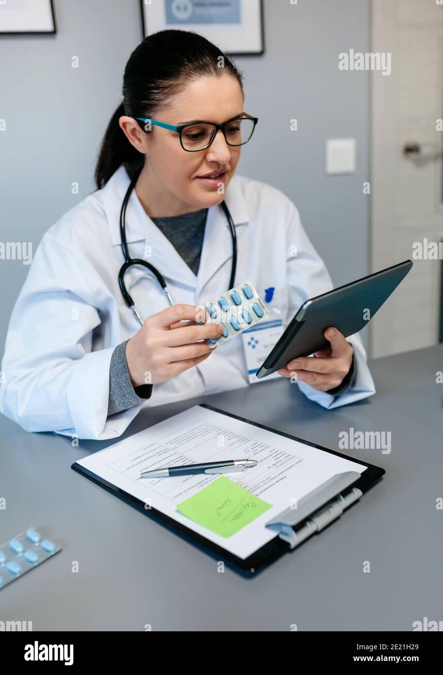 Medico femminile facendo consultazione online mostrando pillole per il trattamento Foto Stock