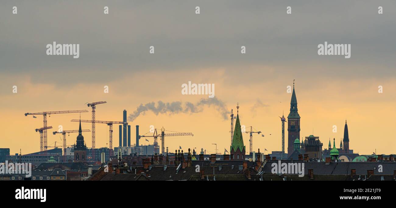 Lo skyline di Copenhagen con le torri della città in un tramonto arancione. Foto Stock