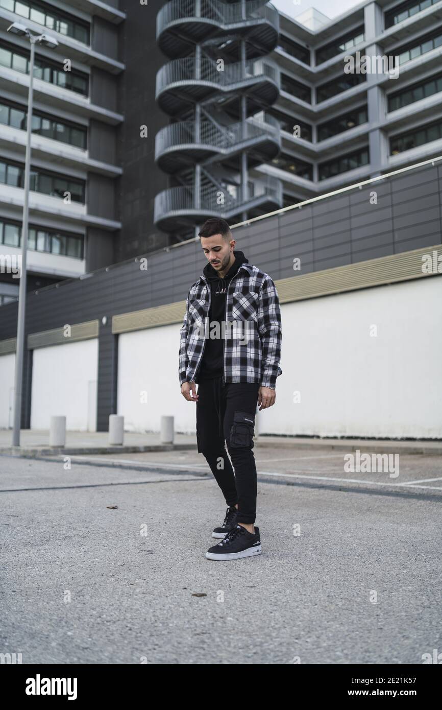 Immagine verticale di un giovane maschio trendy che posa in una  abbigliamento streetwear Foto stock - Alamy