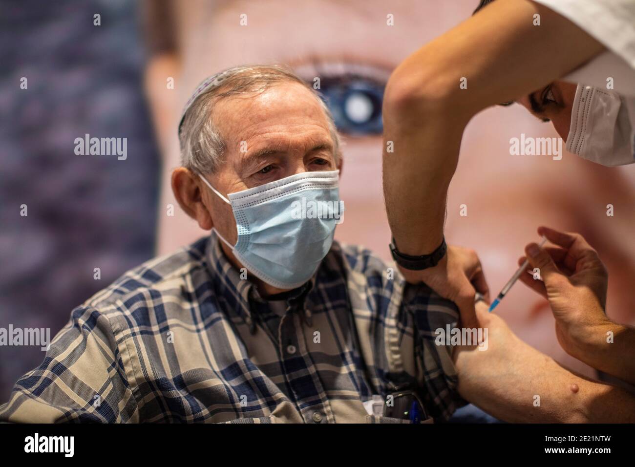 Gerusalemme, Israele. 11 Gennaio 2021. Un uomo riceve la dose del vaccino Pfizer-BioNTech COVID-19 presso un centro di vaccinazione come parte di una campagna nazionale. Il ministro israeliano della Sanità Yuli Edelstein ha detto in precedenza che Israele ha vaccinato il 20 per cento della sua popolazione nelle tre settimane da quando ha iniziato la più grande campagna di vaccinazione della sua storia. Credit: Ilia Yefimovich/dpa/Alamy Live News Foto Stock