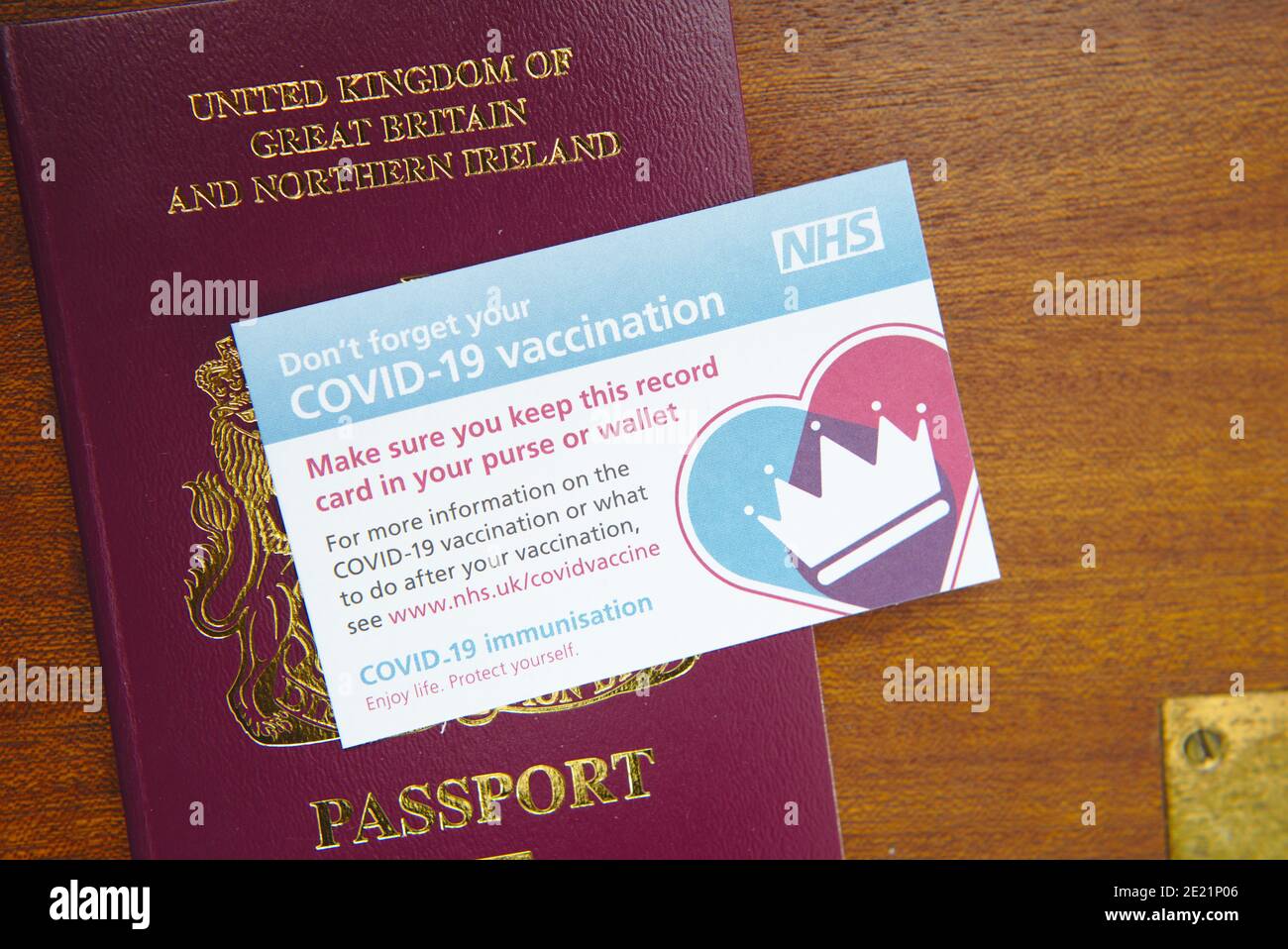 Tessera di registrazione vaccinazioni Covid 19 con passaporto britannico. Una storia vaccinale e l'immunità possono rendere più facile il viaggio dopo la pandemia. Foto Stock