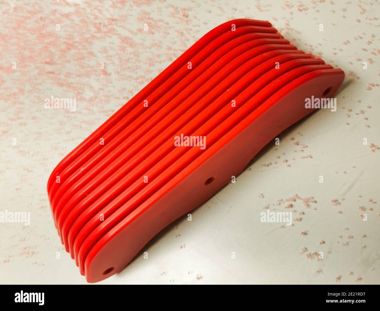 Plastica PET-G fabbricata in rosso con detriti intorno ad essa dall'instradamento dei bordi e con spazio per la copia. Foto Stock