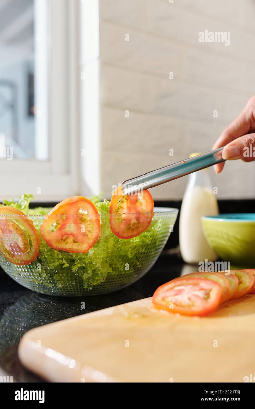 Casalinga decorando ciotola di insalata Foto Stock