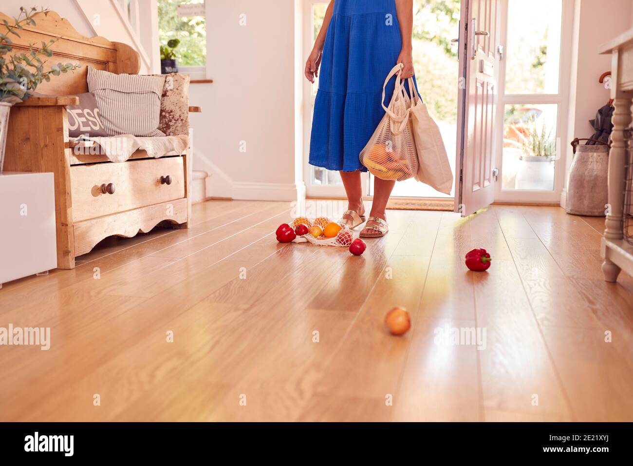 Primo piano di Donna che rilascia prodotti freschi sul pavimento dopo Ritorno da Shopping Trip Foto Stock