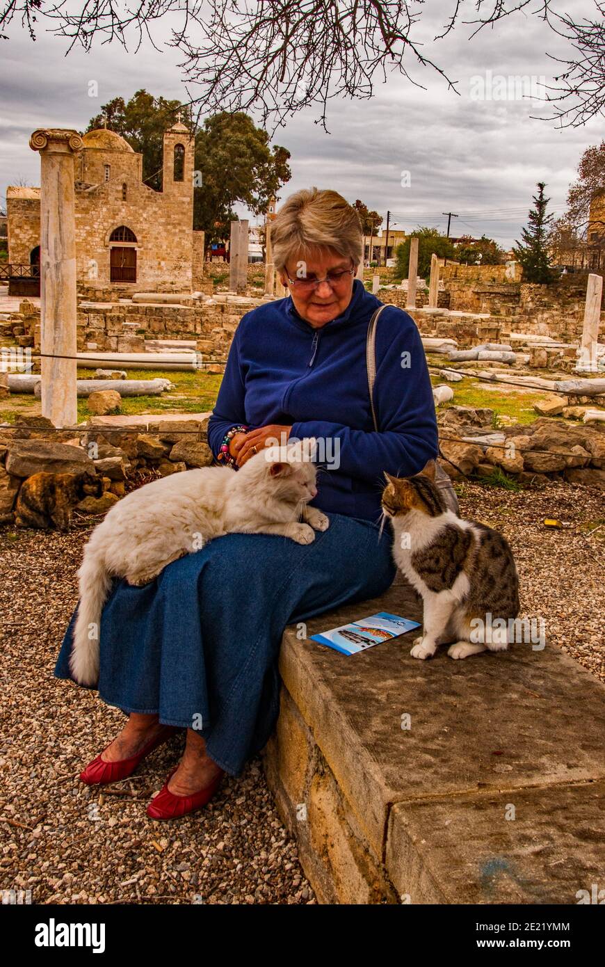 Donna con gatti feriali ad Agia Kyriaki Chrysopolitissa, Paphos, Cipro. Foto Stock