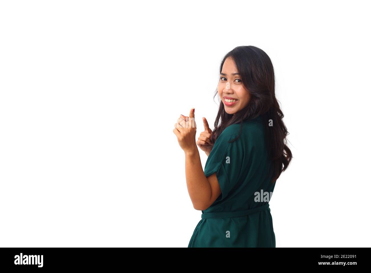 Ritratto del profilo laterale una giovane donna asiatica sorridente mentre guarda e punta una macchina fotografica. Isolato su sfondo bianco con copyspace Foto Stock