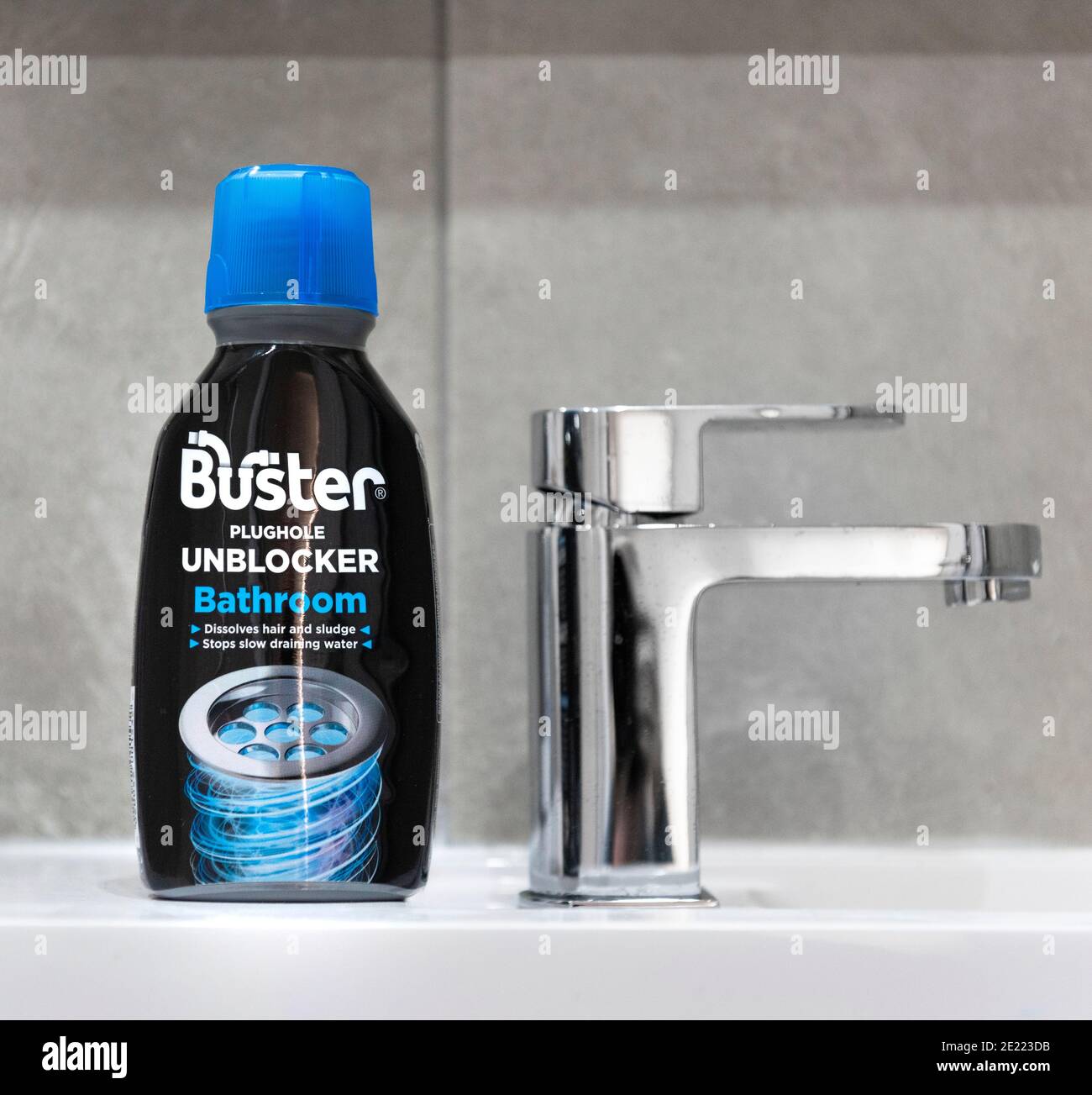 Buster plughole sblocker per bagni in uno sfondo piastrellato Foto Stock