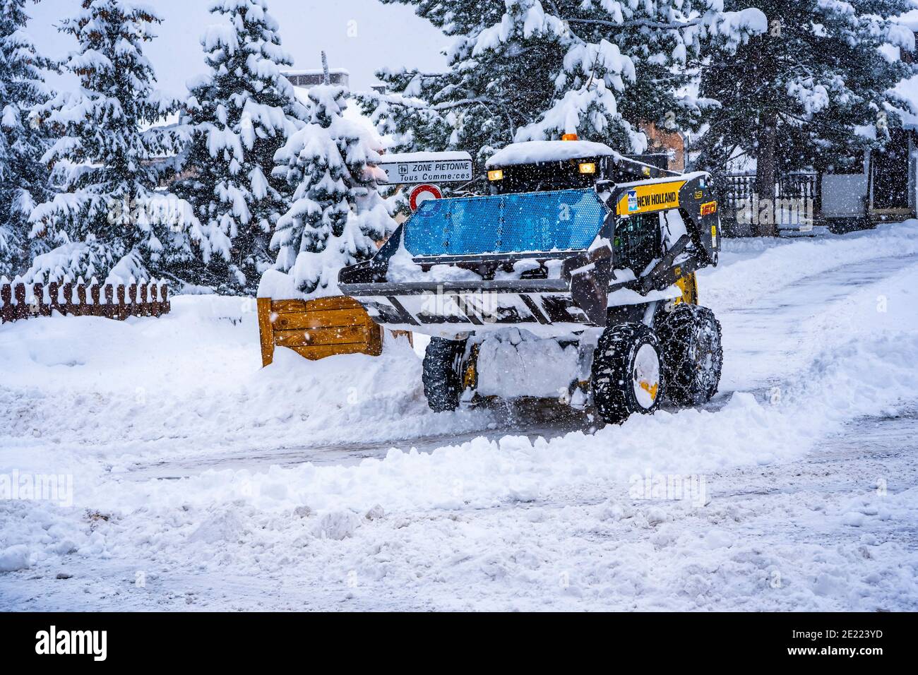 Auron, Francia - 01.01.2021: Pala gommata che rimuove la neve su una stazione sciistica. Eliminare la strada dalla neve. Foto di alta qualità Foto Stock