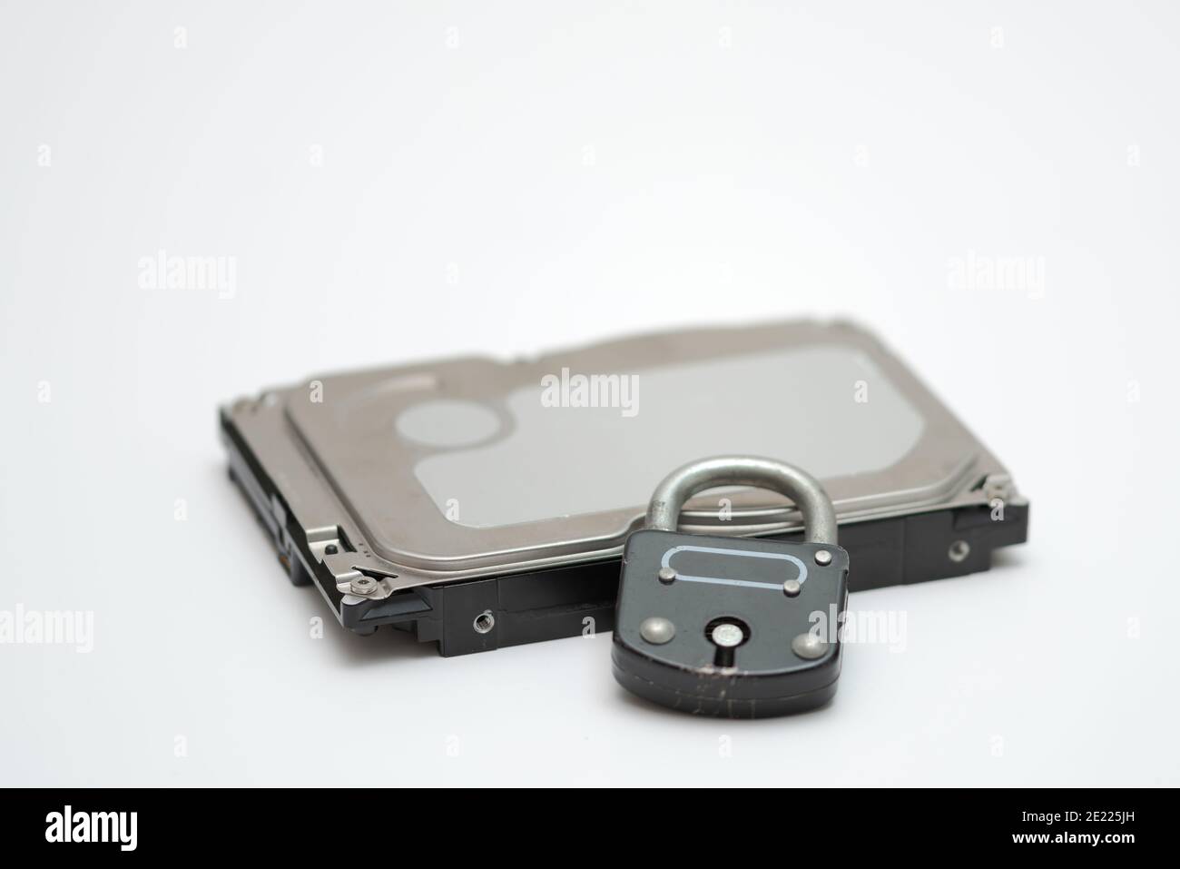 Computer hard disk e lucchetto metallico simboleggiano il concetto di crittografia dei dati, sicurezza informatica Foto Stock