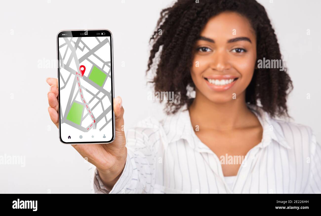 Smartphone Black Lady Holding con mappe online di navigazione GPS aperte Sullo schermo Foto Stock