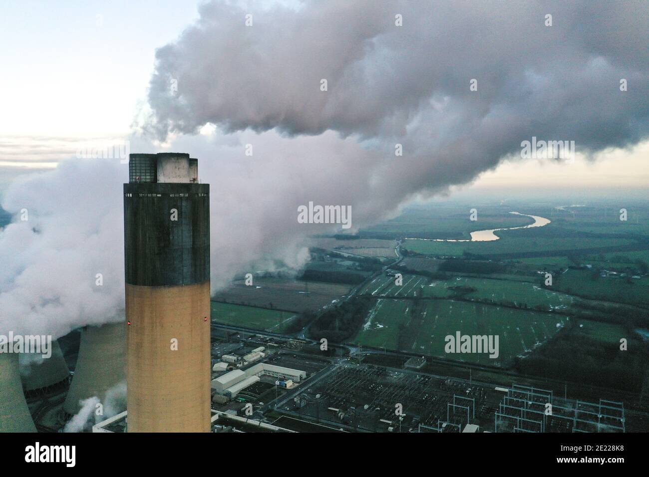 Un'immagine aerea della cima di un carbone sparato Camino della centrale elettrica che emette anidride carbonica inquinante nella parte superiore atmosfera con spazio per la copia Foto Stock