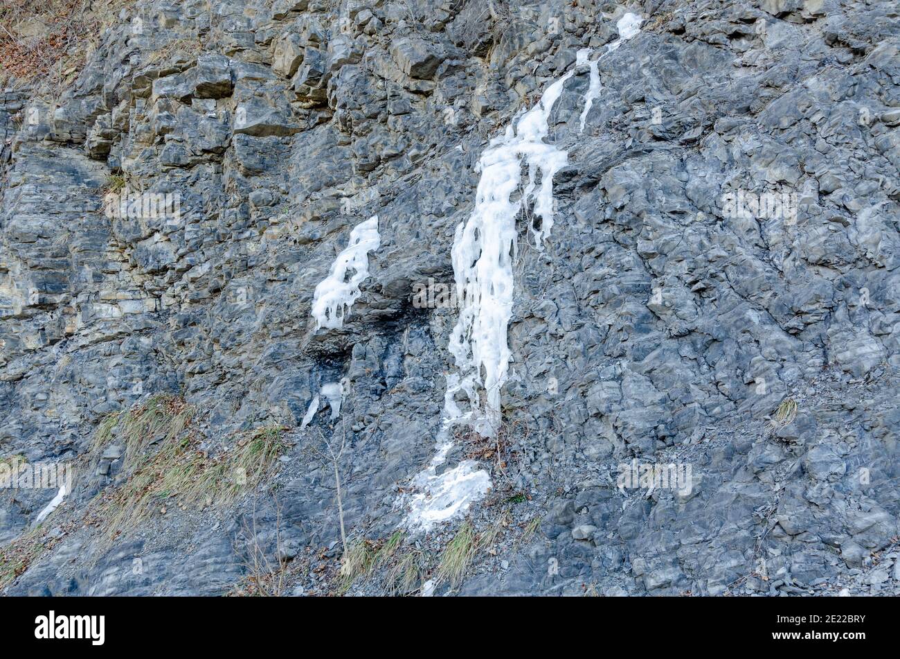 Fuoriuscita di acqua congelata da una parete di roccia Foto Stock