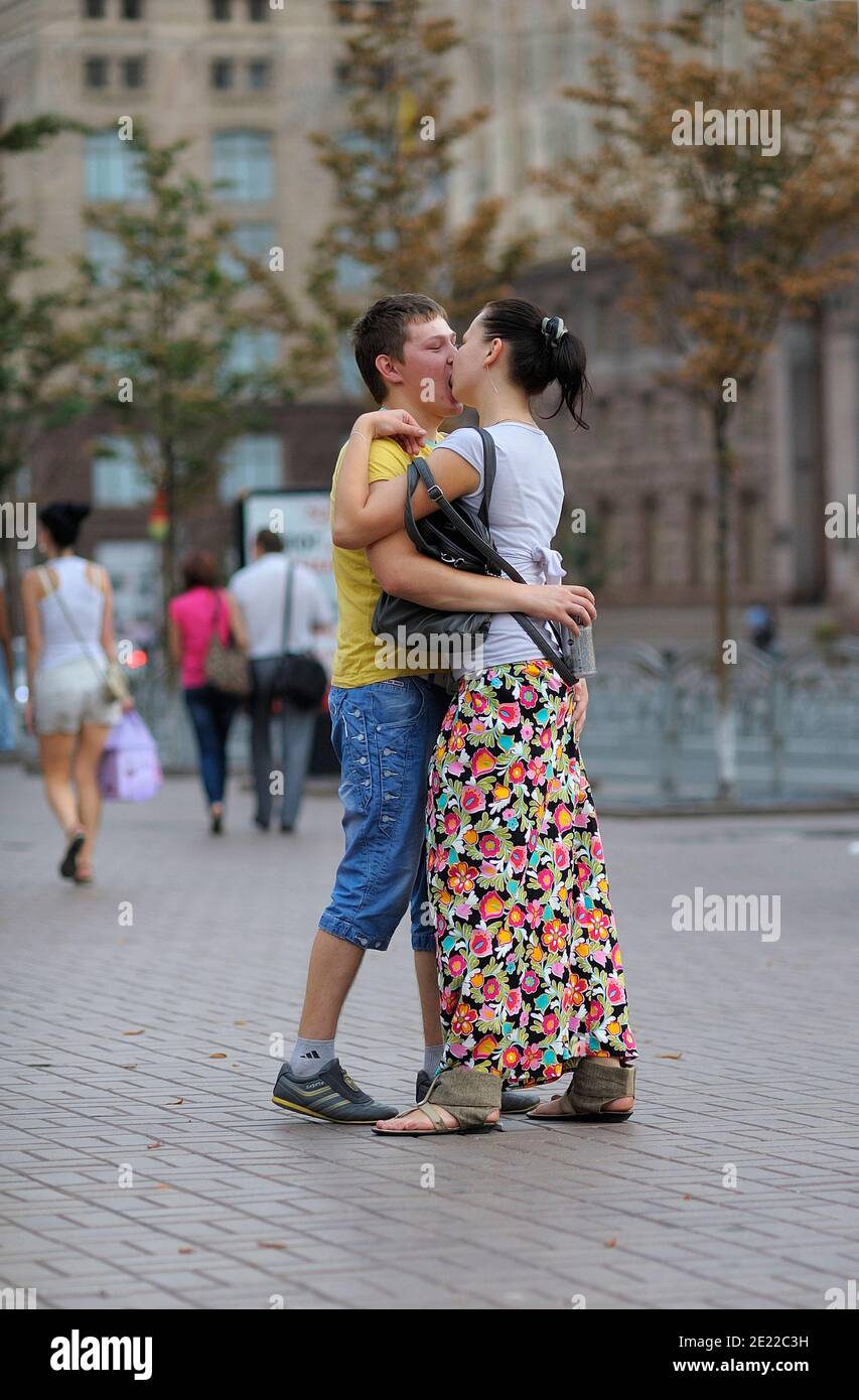 Il ragazzo ubriaco balla con una ragazza su una strada che tiene una lattina con la birra nelle mani, gente offuscata che cammina su uno sfondo. 11 luglio 2012. Kiev, Ucraina Foto Stock