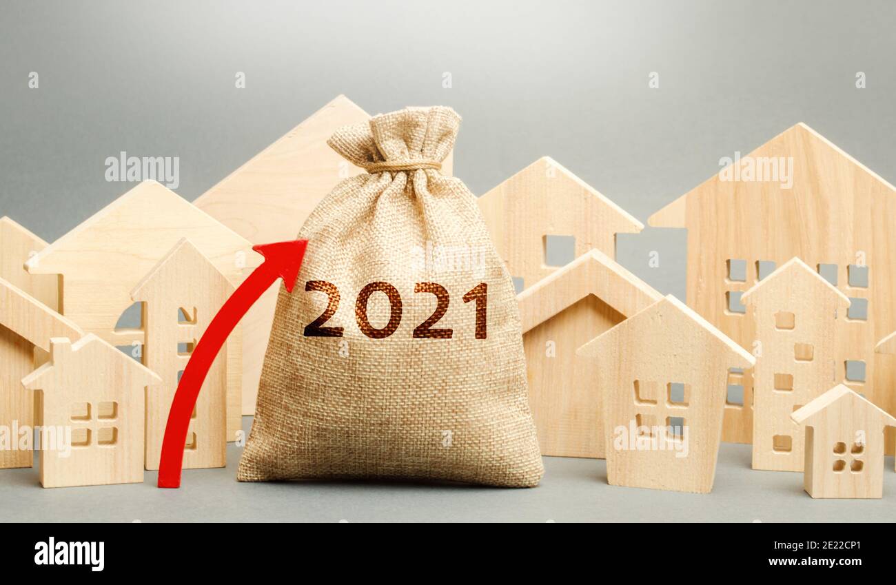 borsa di 2021 soldi con freccia in su e case in miniatura. Pianificazione immobiliare e concetto di finanziamento. Mercato immobiliare. Ipoteca, prestito, investimento. Riparazioni e. Foto Stock