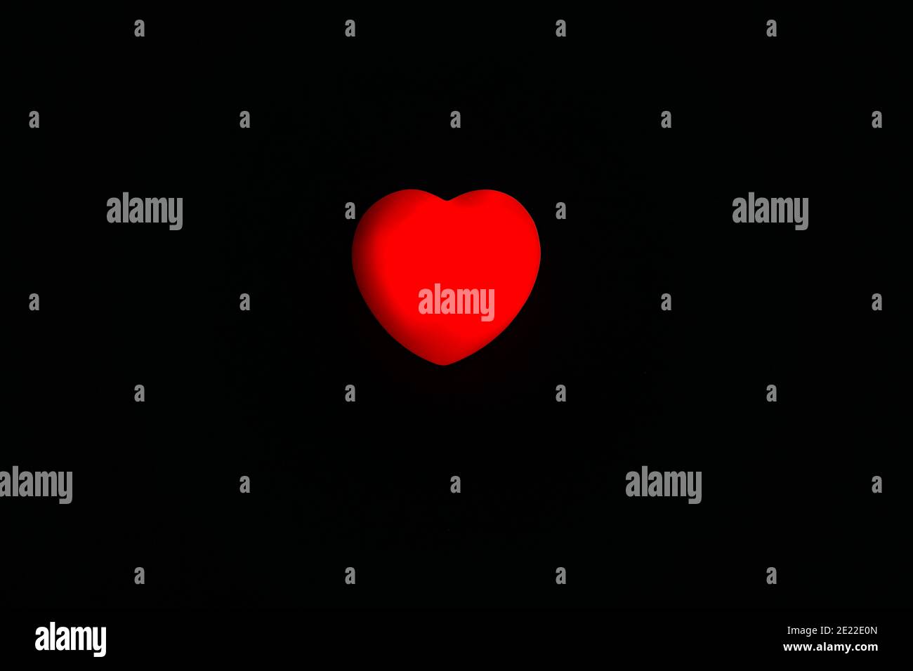 Primo piano cuore rosso su sfondo nero, amore, cura e concetto di San Valentino. Foto Stock