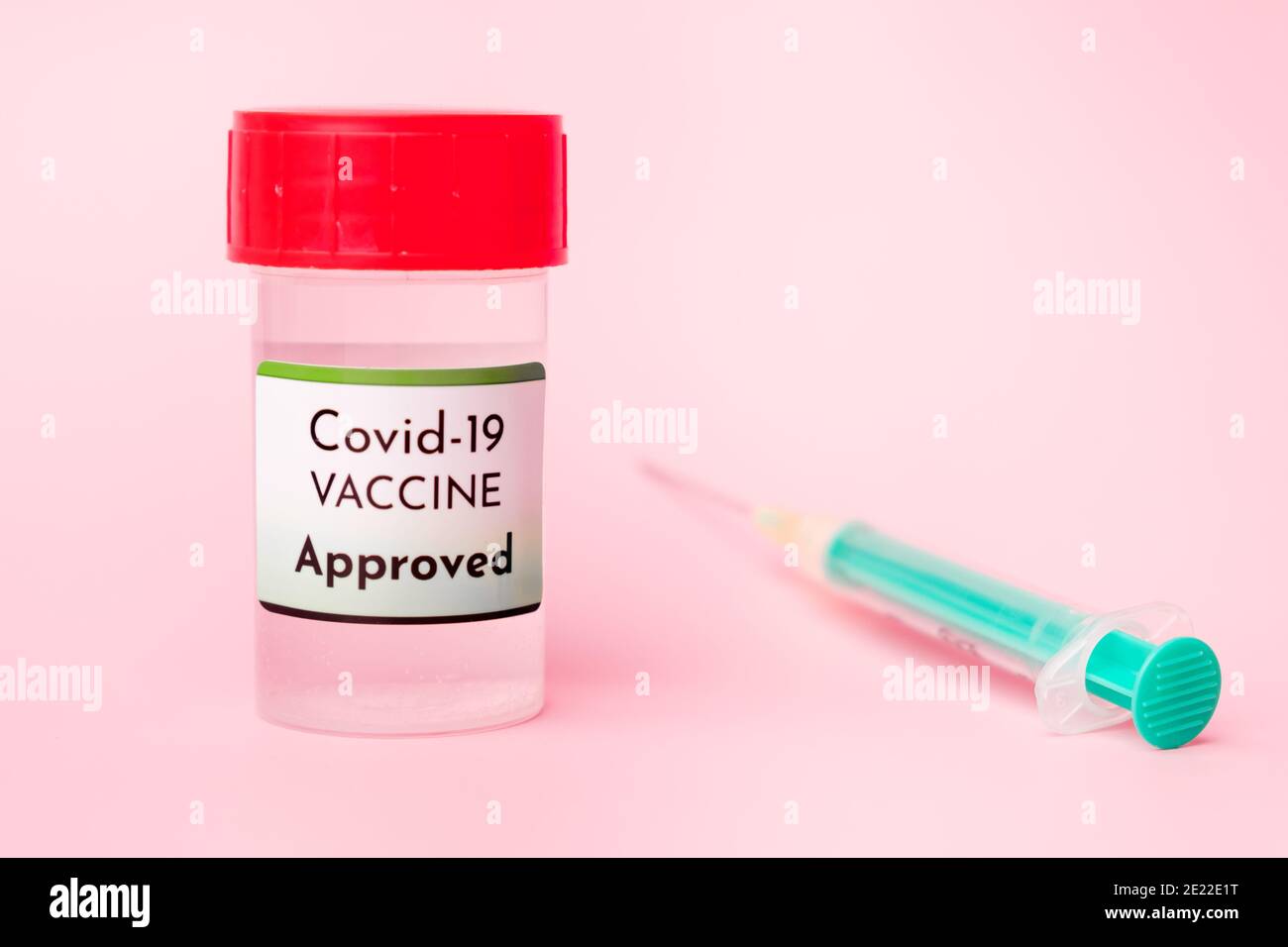 Vaccino Covid-19 approvato nel flacone e siringa monouso per iniezione su fondo rosa. Prevenzione del coronavirus, Sars-Cov-2. Foto Stock