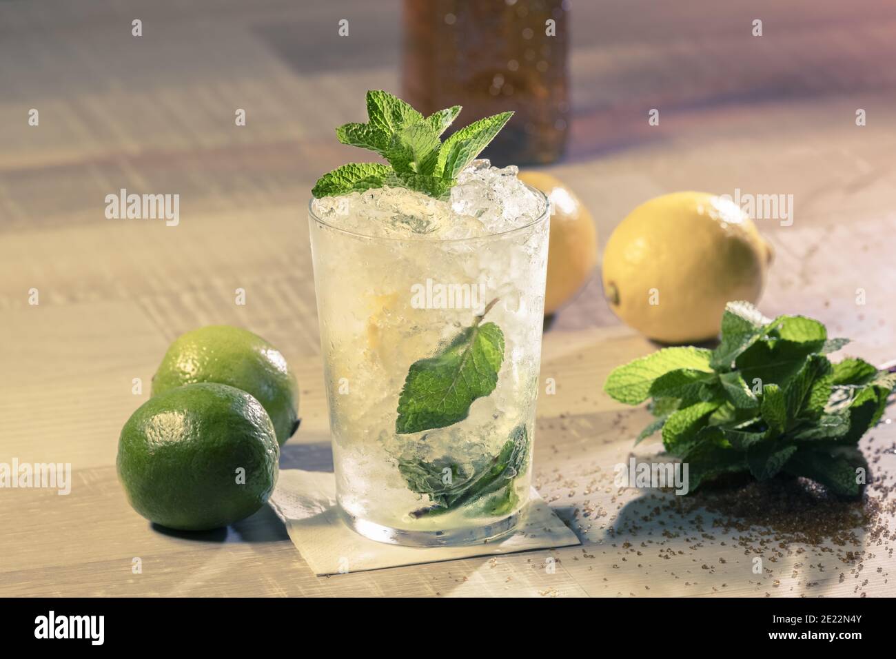 Primo piano di un bicchiere di mojito con foglie di menta, limone e lime sul tavolo Foto Stock