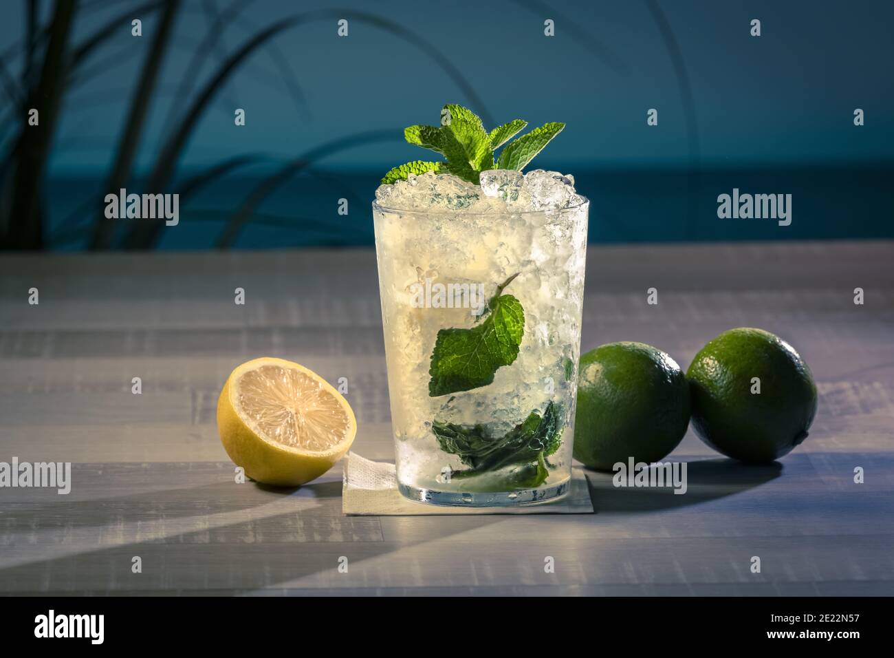Primo piano di un bicchiere di mojito con foglie di menta, limone e lime sul tavolo Foto Stock