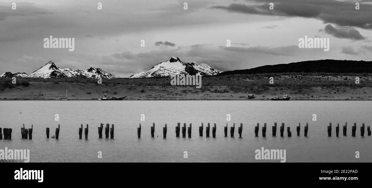 Immagine in bianco e nero del vecchio molo con le Ande in lontananza a Puerto Natales, Patagonia, Cile, Sud America Foto Stock