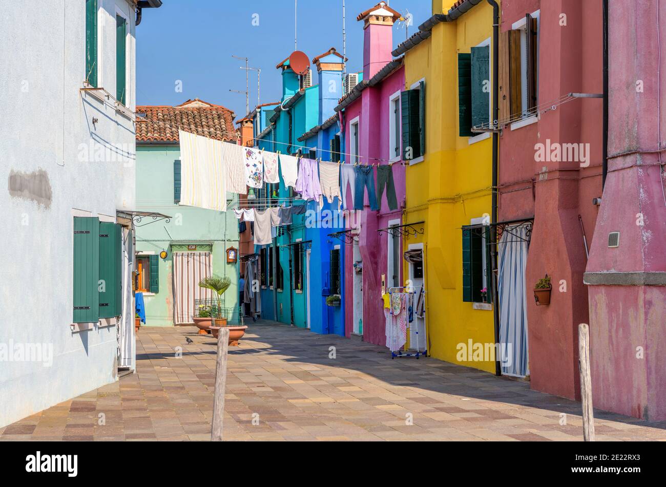 Vicolo colorato - una vista di giorno luminoso e soleggiato di uno dei molti vicoli colorati sull'Isola di Burano nella Laguna Veneziana del Nord Italia. Foto Stock
