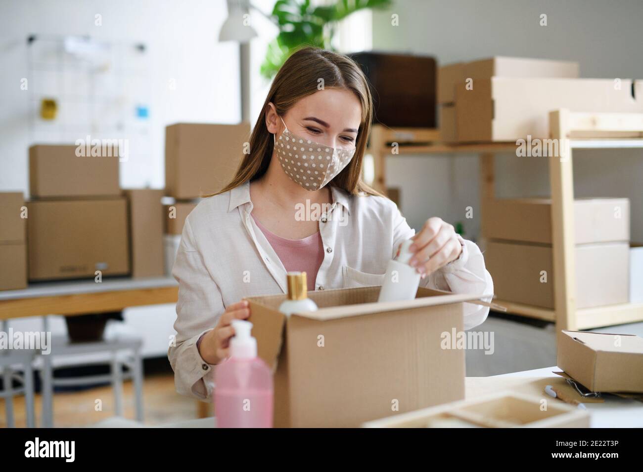 Giovane donna dropshipper che lavora a casa, elaborando gli ordini. Concetto di coronavirus. Foto Stock