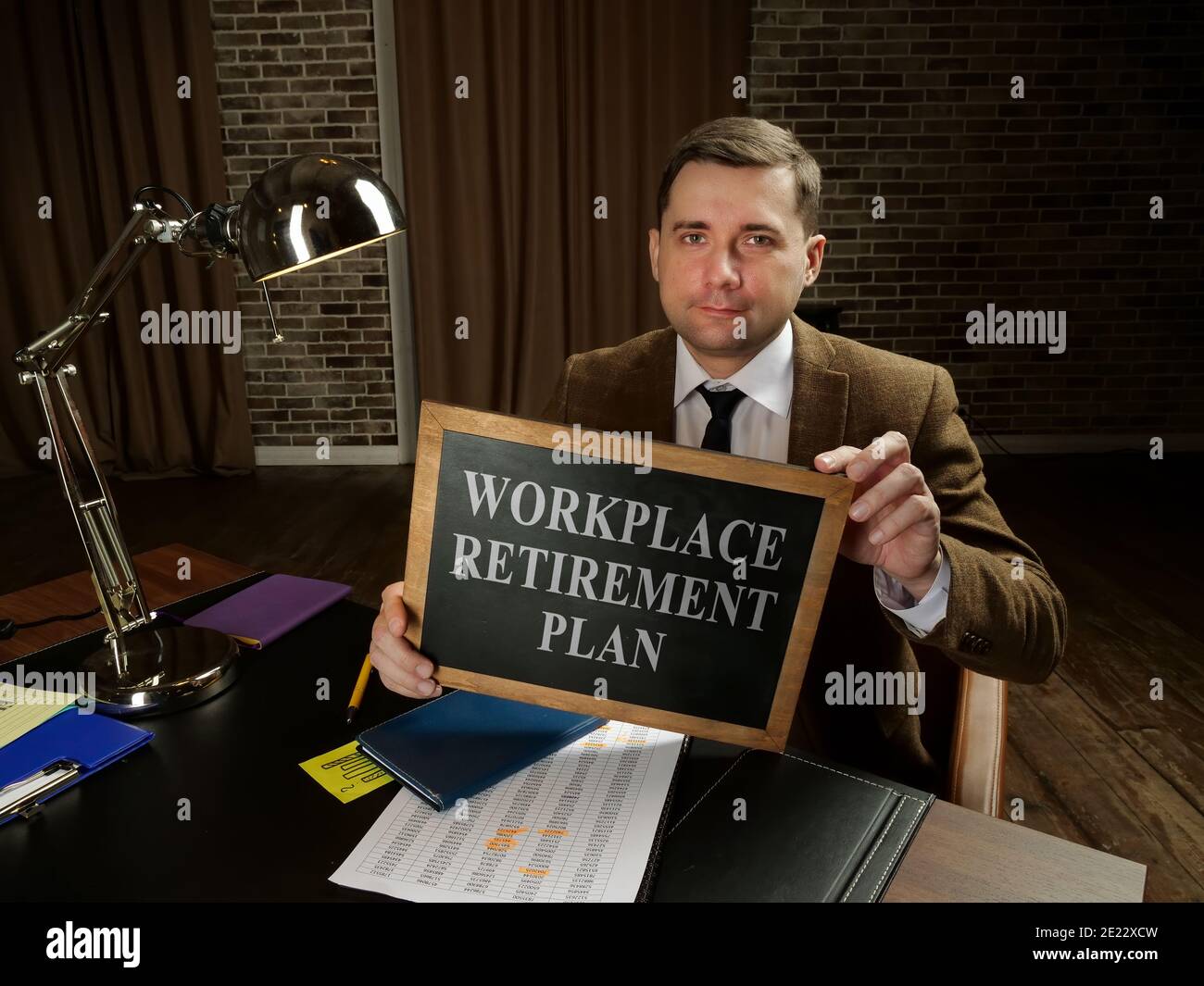 Concetto di piano di pensionamento sul posto di lavoro. Il direttore tiene un cartello con l'iscrizione. Foto Stock