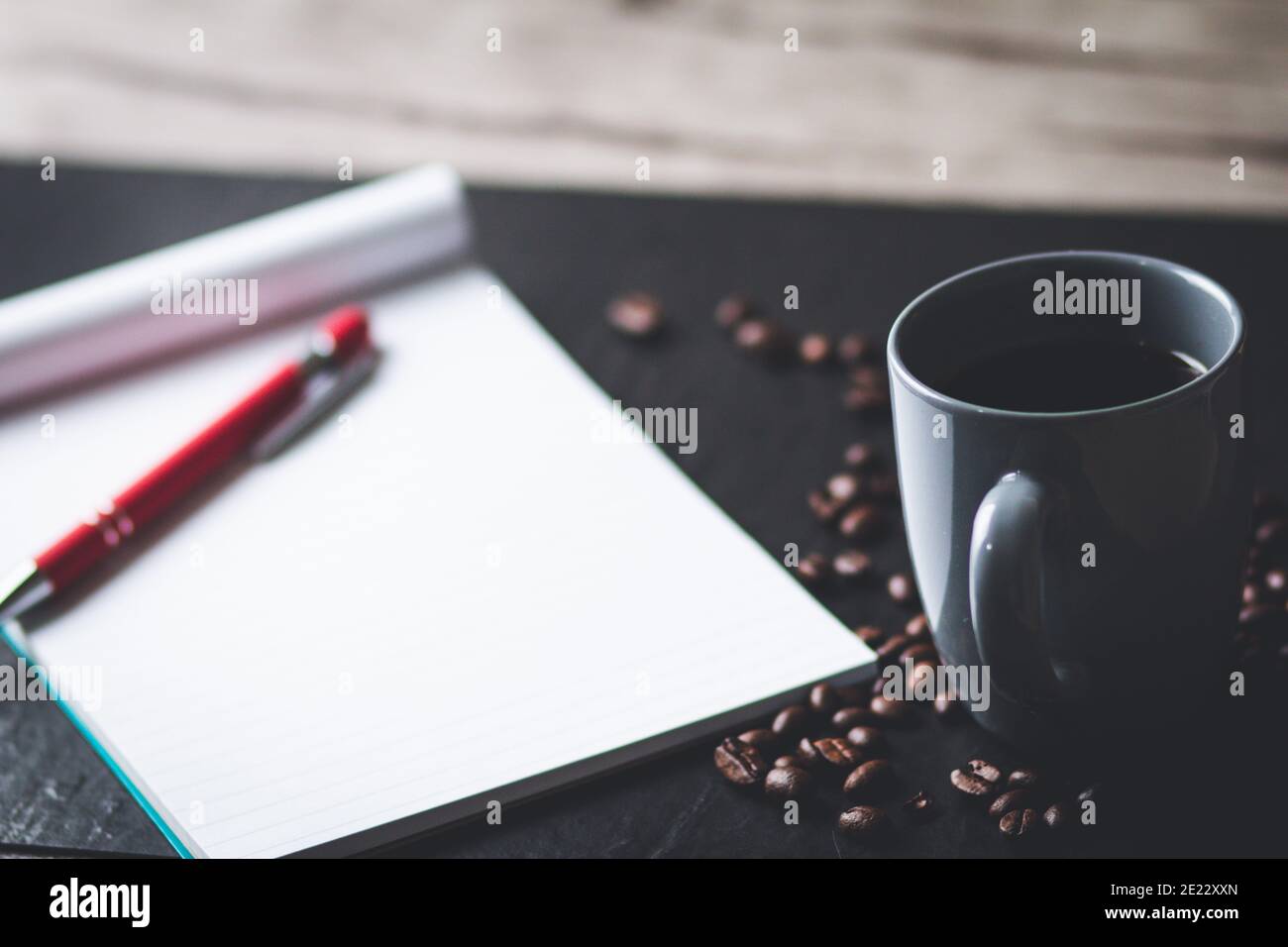 Messa a fuoco selettiva di un blocco note, penna e una tazza di caffè caldo - il concetto di lavoro da casa Foto Stock