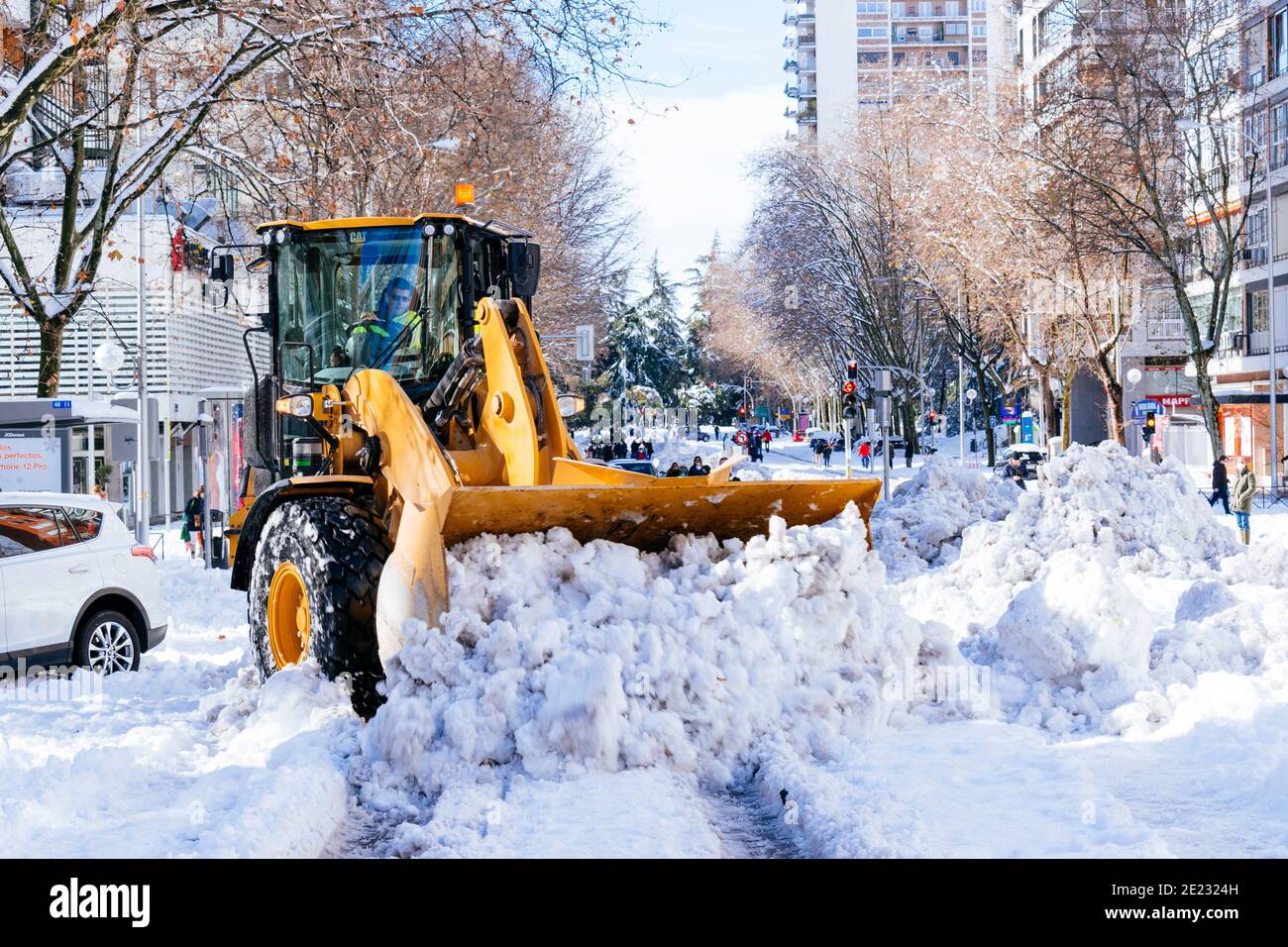 Un digger CAT pulisce Alberto Alcocer strada di neve. Il giorno dopo Filomena nevicata pesante. Madrid, Spagna Foto Stock