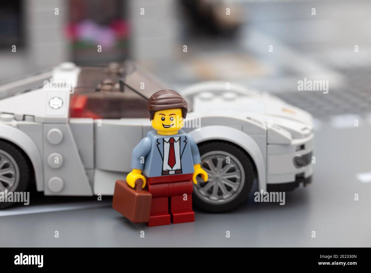 Tambov, Federazione Russa - 08 gennaio 2021 minififeuna uomo d'affari Lego in piedi vicino alla sua auto sportiva. Foto Stock