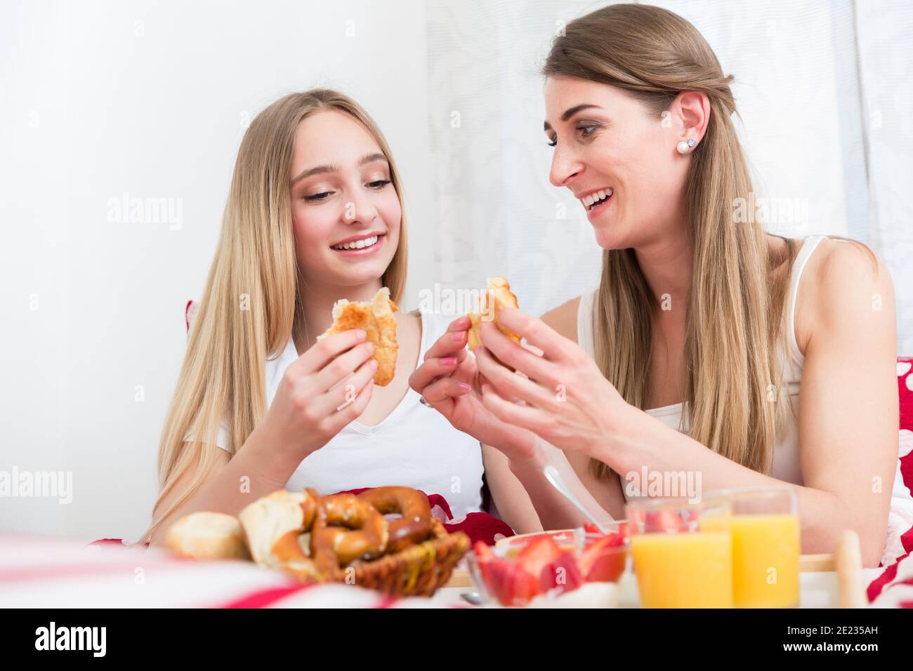 Madre e figlia che hanno la prima colazione a letto Foto Stock
