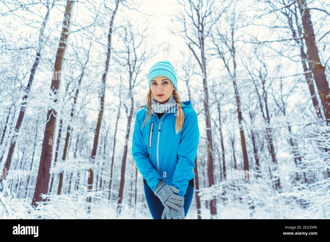 Donna che indossa abiti funzionali in neve che si riscalda per lo sport Foto Stock