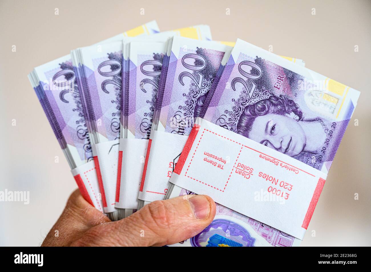 Primo piano della mano che tiene £5000 contanti in 20 £banconote. Valuta britannica. Sterlina britannica. Foto Stock