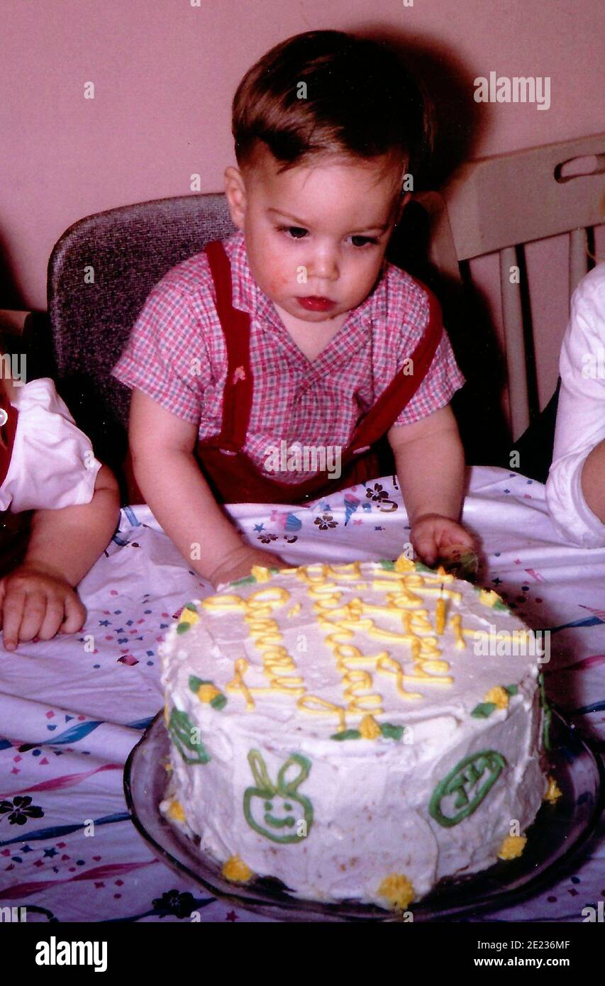 Un ragazzino pronto a gustare la sua torta di compleanno dentro 1970 Foto Stock