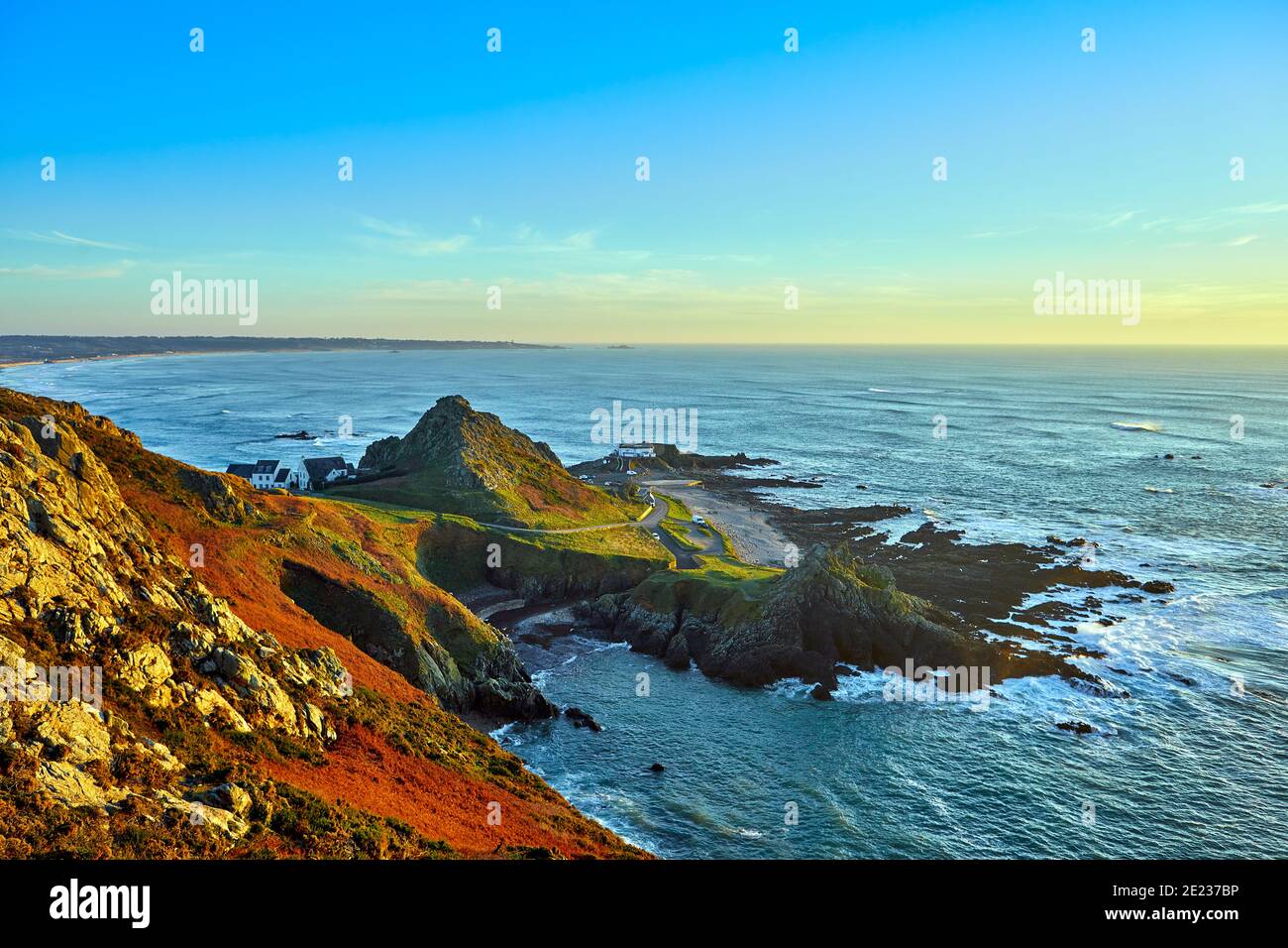 Immagine della costa occidentale del Jersey con l'Etacq in primo piano e la Baia di St Ouens sullo sfondo al tramonto. Ci Jersey Foto Stock