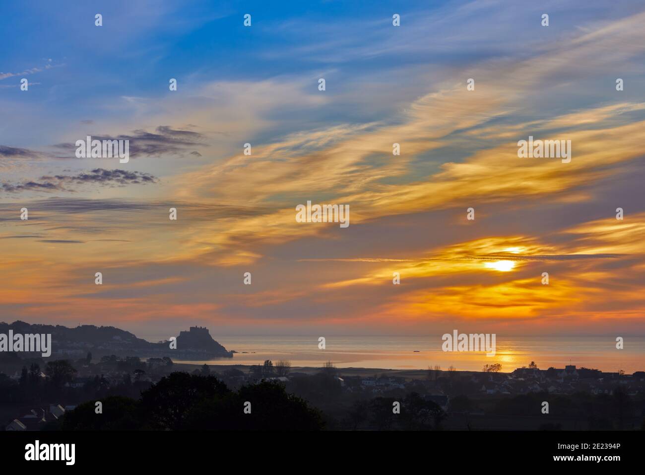 Immagine della baia di Grouville con il castello di Gorey sullo sfondo con un mare liscio al tramonto. Isole del canale di Jersey Foto Stock