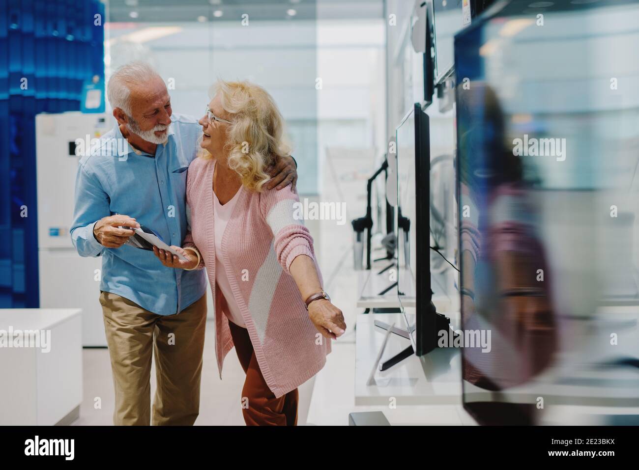 Bella coppia senior presso il negozio di tecnologia. Alla ricerca di una nuova Smart TV. Foto Stock