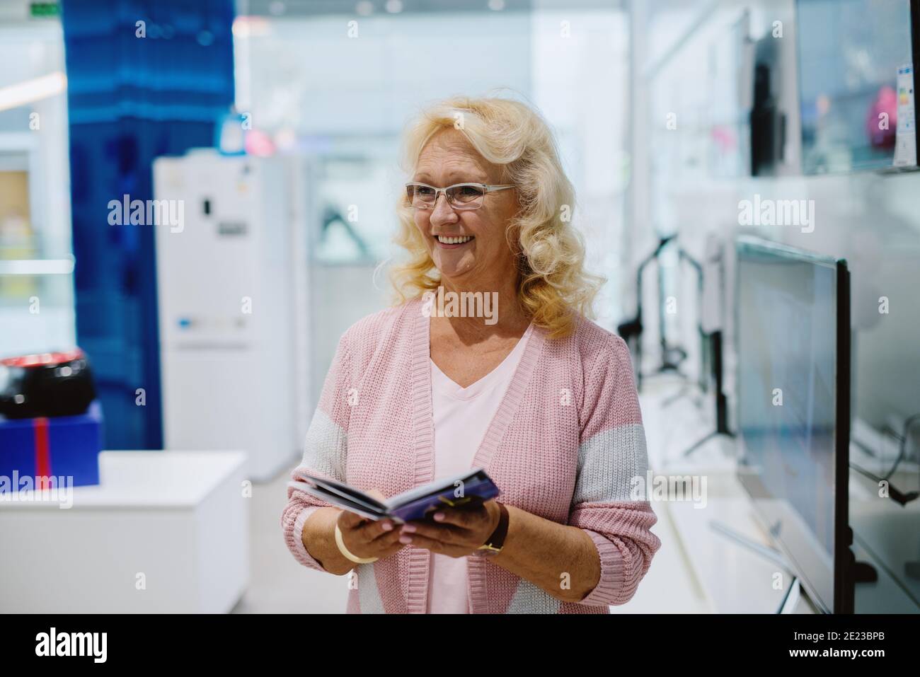 Bel ritratto di donna anziana al negozio di tecnologia. Foto Stock