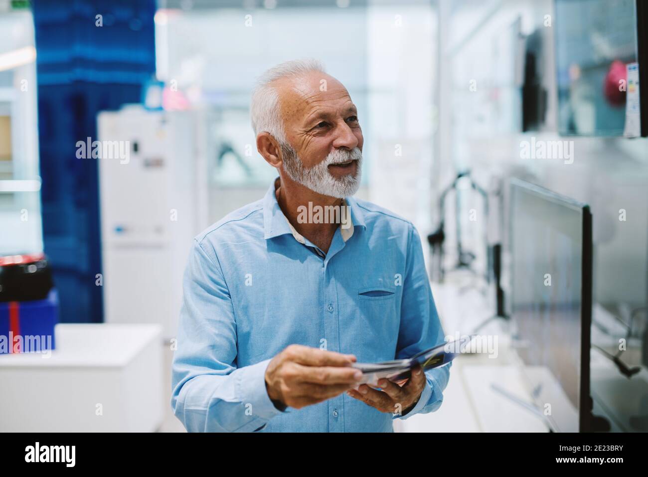 Bel ritratto di uomo anziano al negozio di tecnologia. Foto Stock