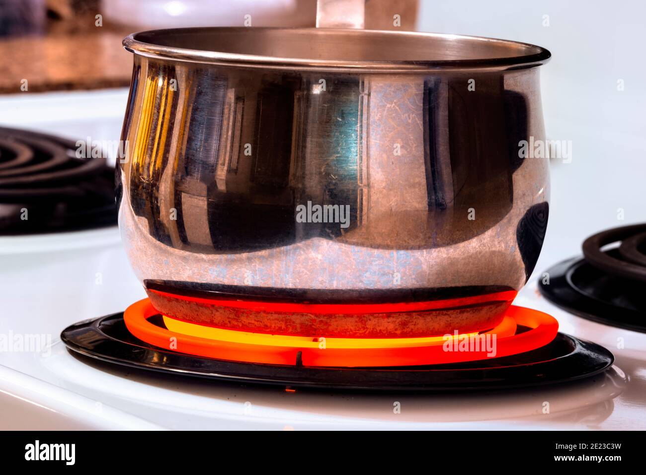 Colpo orizzontale di una pentola di cottura su un bruciatore di cima di stufa molto caldo. Foto Stock