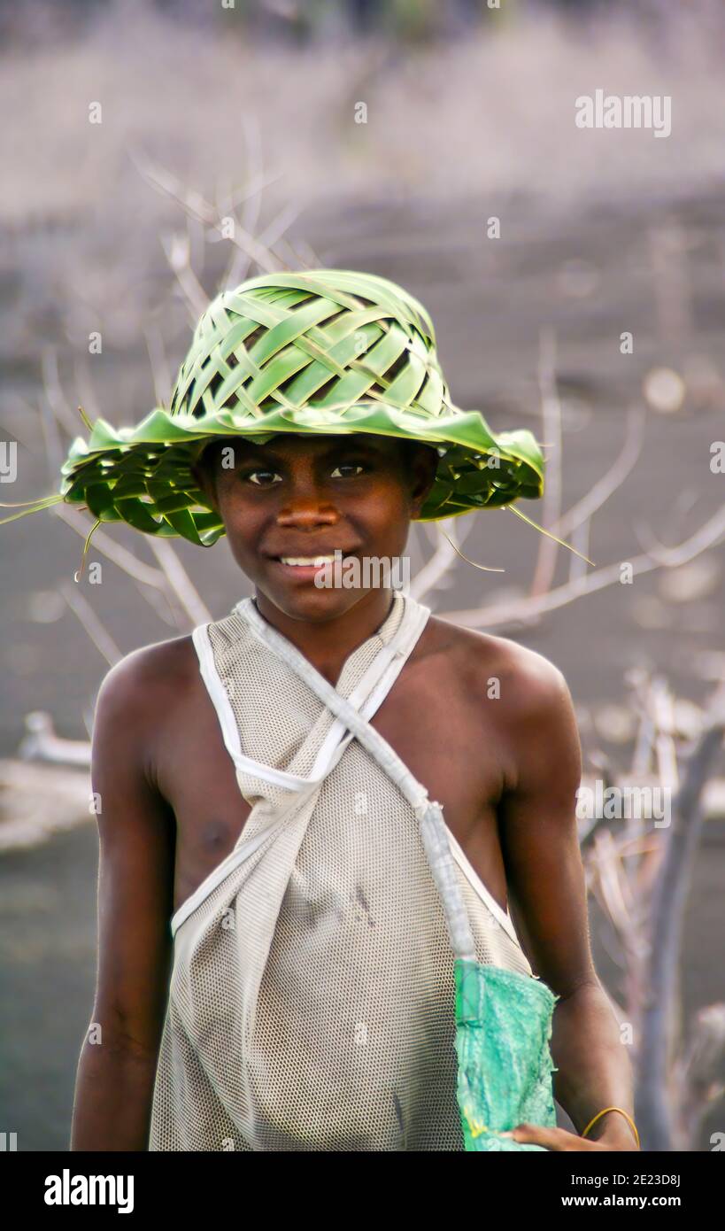 Un ragazzo giovane che indossa un cappello intrecciato da palma si pone per un'immagine. Rabaul; Papua Nuova Guinea; NMR Foto Stock