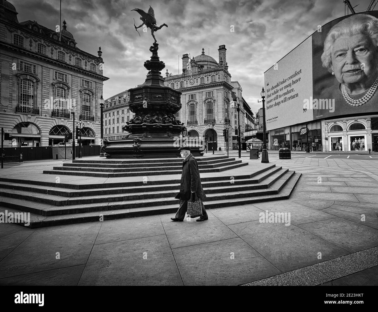 Il discorso del Queens coronavirus è illuminato sul tabellone del Piccadilly Circus mentre continua il blocco del Regno Unito. Un uomo passa davanti al vuoto Piccadilly Circus. Foto Stock