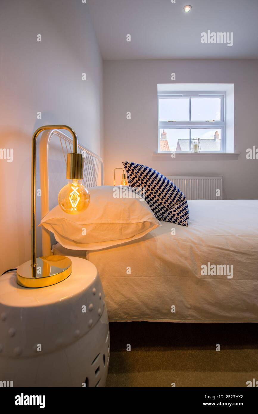 Camera da letto vista con punto focale di calda lampada da comodino Foto Stock
