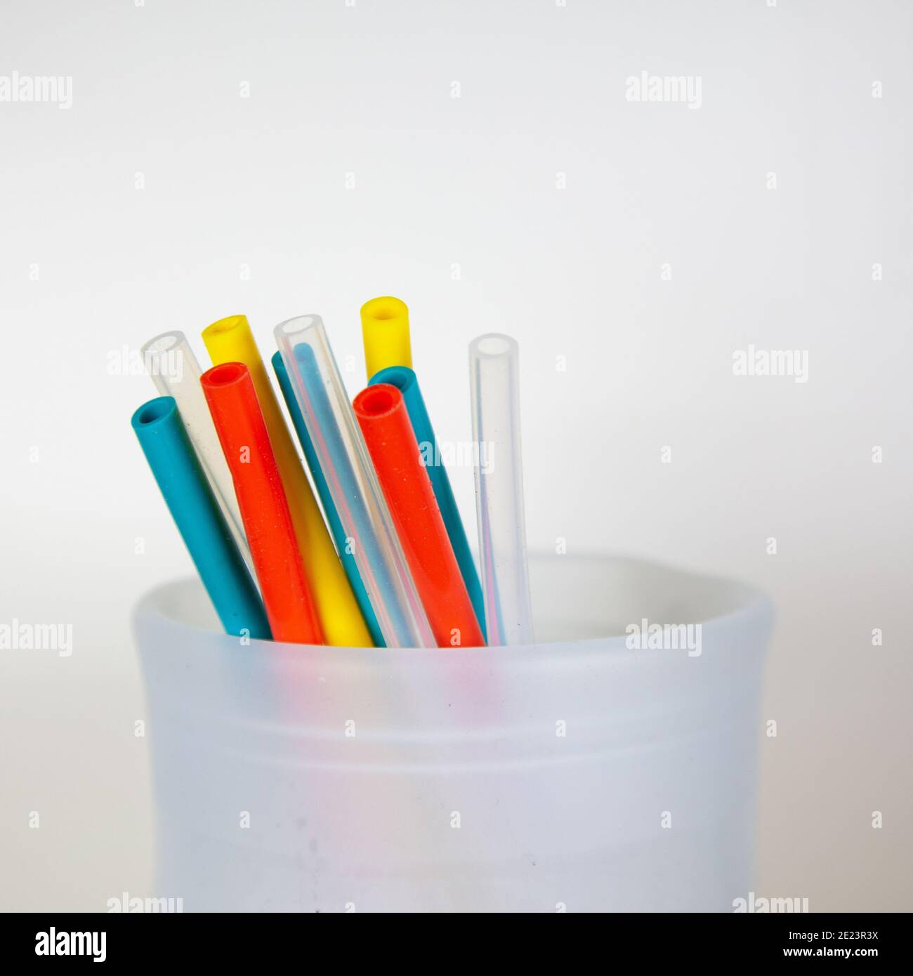 Un primo piano di una sacca in silicone per alimenti che contiene diversi cannucce riutilizzabili in silicone di colore, un'alternativa in plastica più sostenibile ed eco-compatibile Foto Stock