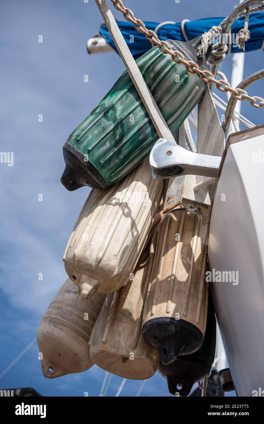 I parafanghi della barca pendono in un mazzo immagazzinato fuori della poppa di una barca a vela da crociera. Foto Stock