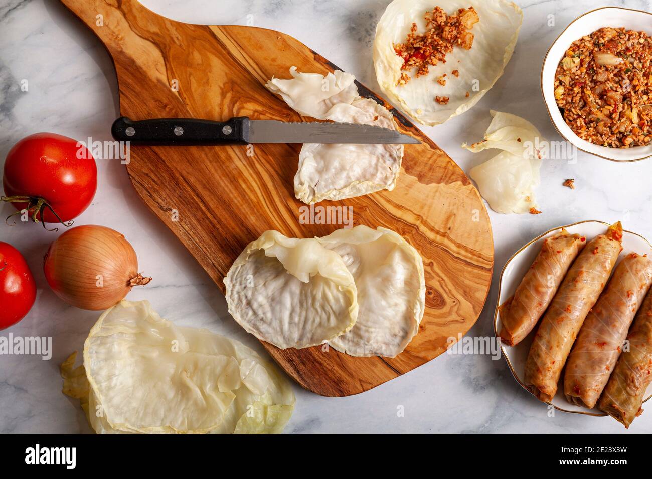 Immagine piatta delle foglie di cavolo appiattite su trivella di legno, ripiena con un ripieno di una miscela di carne macinata di riso, pomodoro, cipolla ed erbe Foto Stock