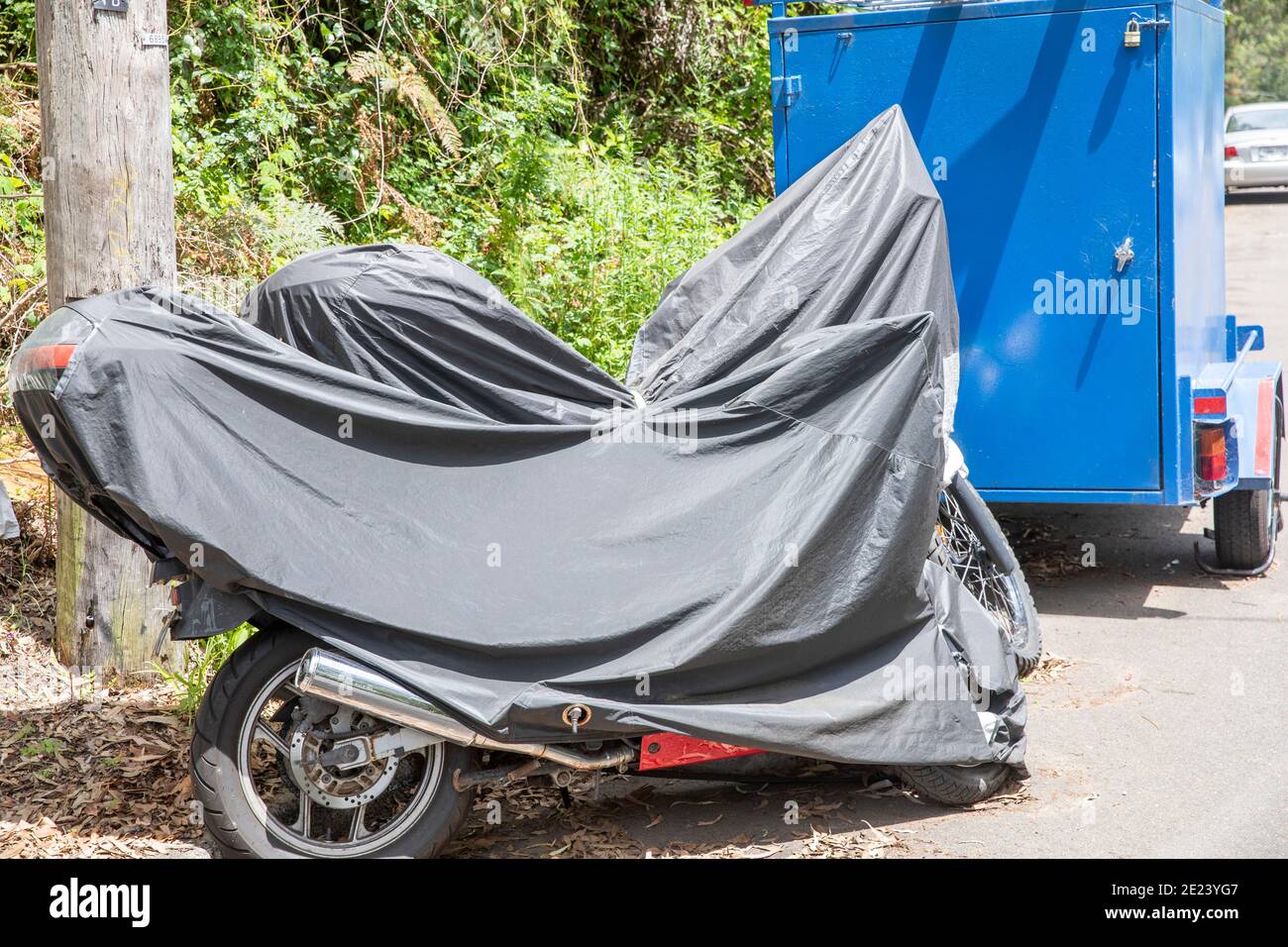 Due moto in una strada di Sydney coperta da pioggia protettiva copertura solare, Australia Foto Stock