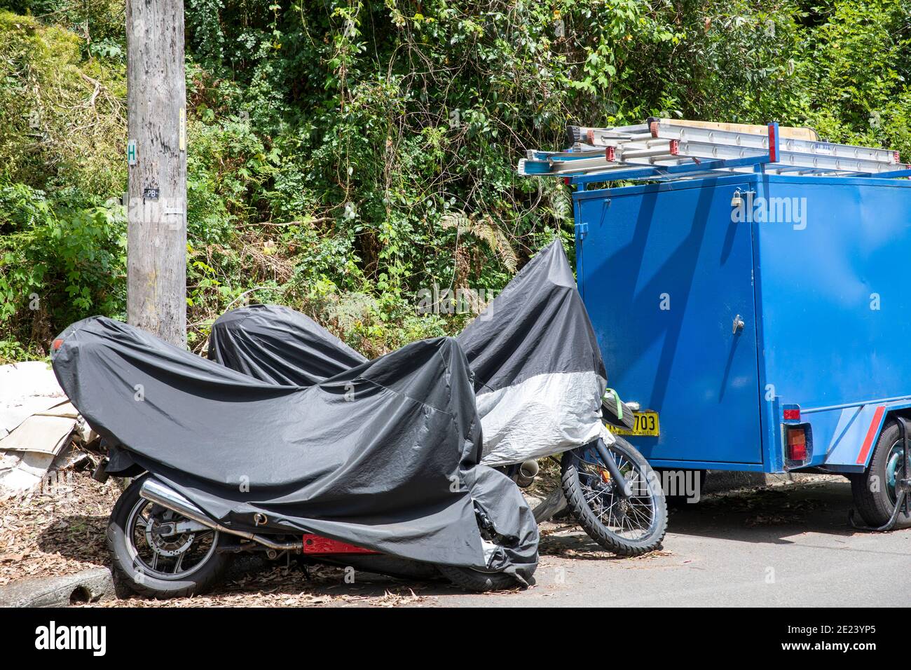 Due moto in una strada di Sydney coperta da pioggia protettiva copertura solare, Australia Foto Stock