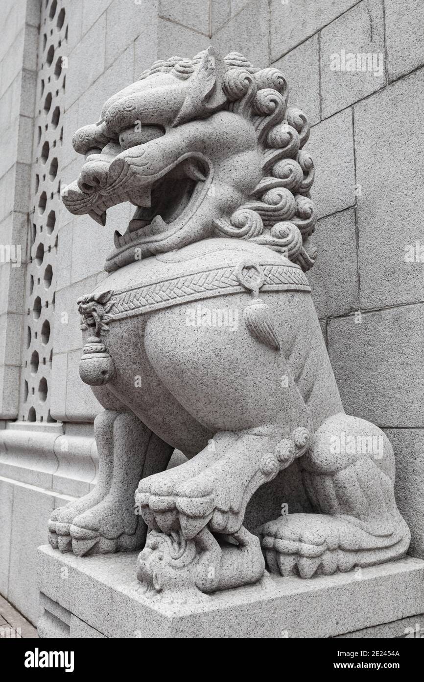 Tradizionale statua di leone cinese in pietra bianca all'ingresso di Tempio buddista nella città di Hong Kong Foto Stock