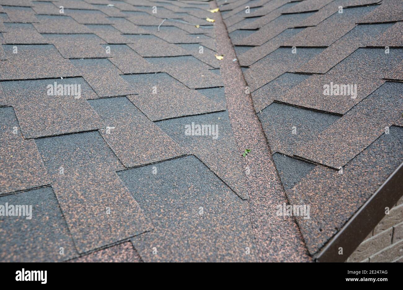 Un primo piano dell'angolo del tetto con alette in asfalto, intersezione del tetto con il lampeggio del tetto installato per evitare perdite d'acqua. Ispezione di un'area problematica del tetto, Foto Stock