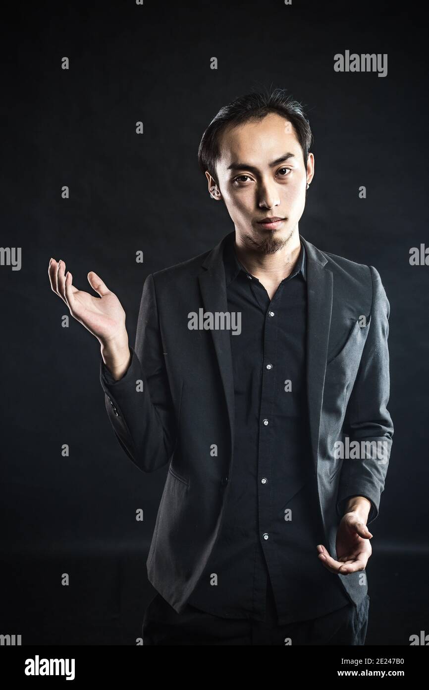 Uomo asiatico in una camicia bianca con abito grigio in illuminazione  studio su sfondo grigio Foto stock - Alamy